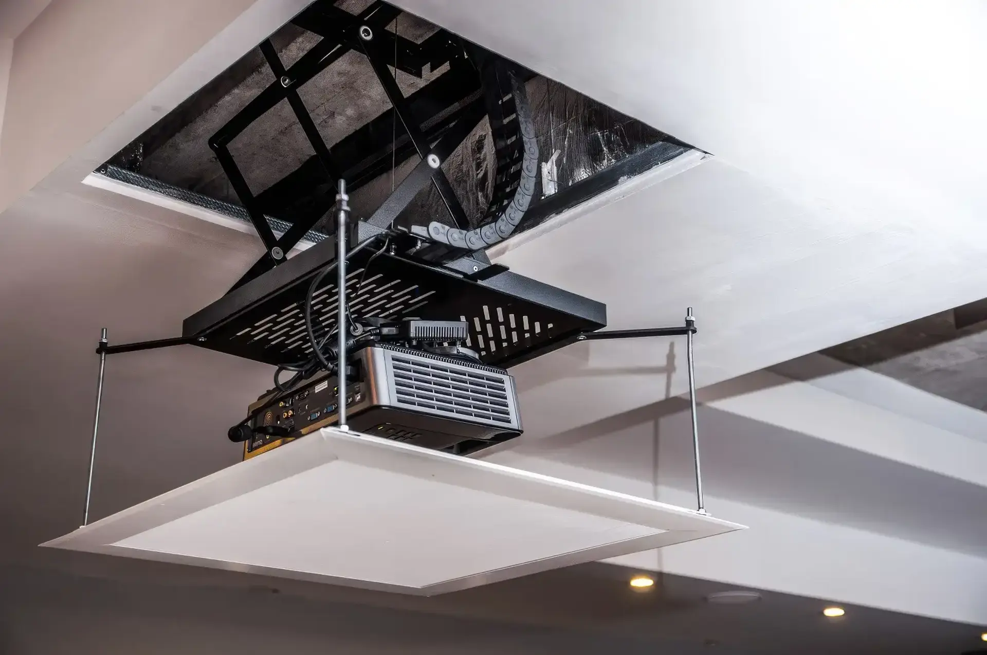 A projector mounted to a motorised mechanism lowered from the ceiling